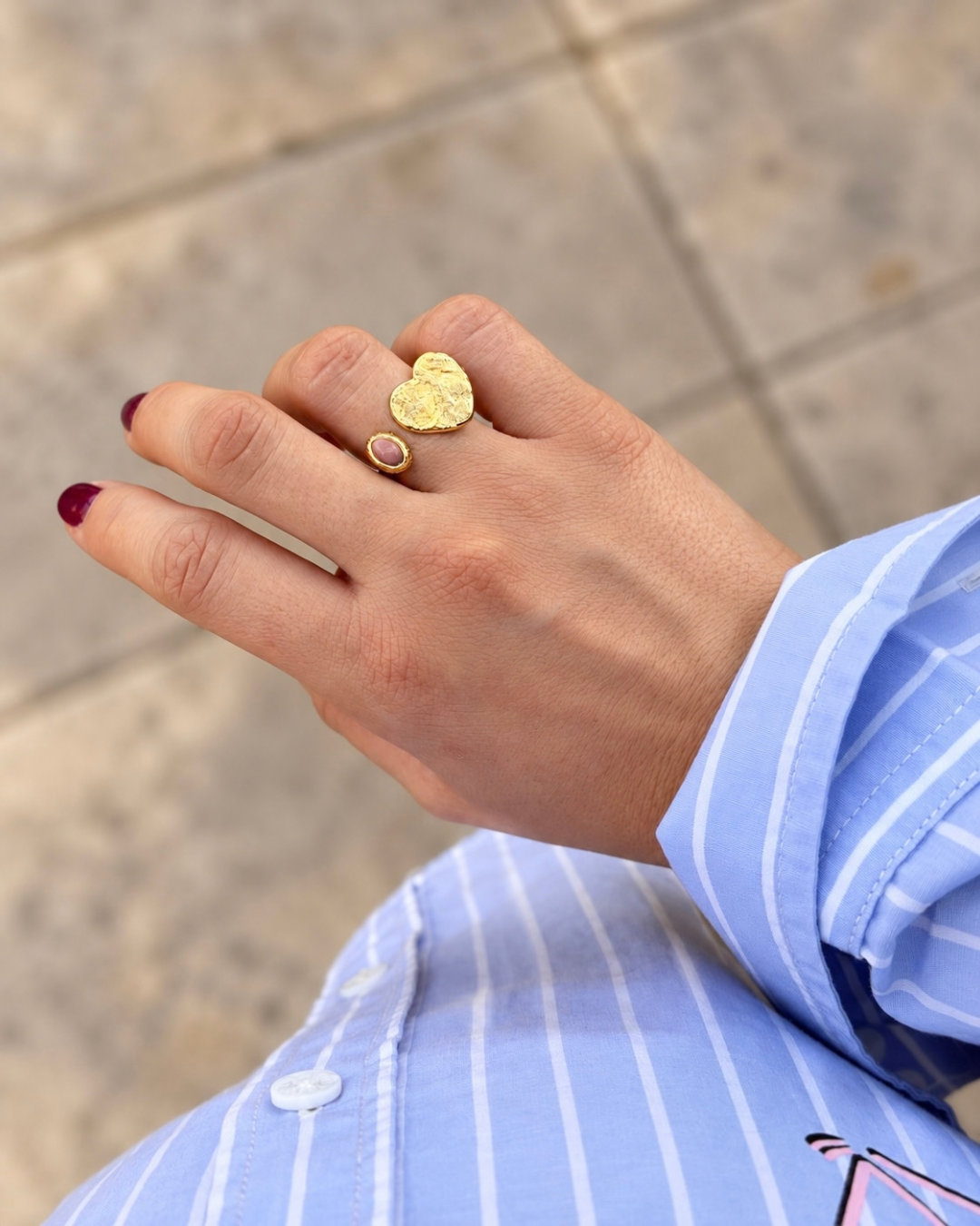 Mano con el anillo Éloise de corazón dorado martillado sobre camisa de rayas azul — Ayutthaya&me